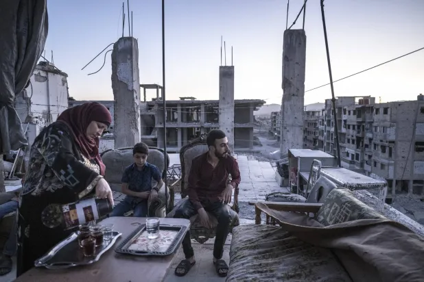 عائلة تتجمع في ما تبقى من شقتها المدمرة بداريا إحدى ضواحي دمشق (نيويورك تايمز)