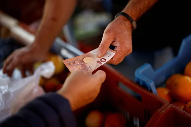 زبون يدفع 10 يوروات في سوق بمدينة نانت الفرنسية (رويترز)