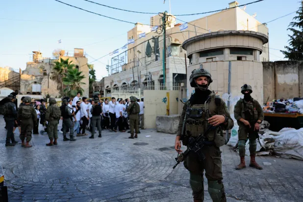 جنود إسرائيليون ينتشرون خلال جولة أسبوعية للمستوطنين في الخليل بالضفة الغربية (رويترز)