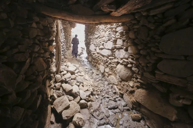 أحد السكان المحليين يسير بجوار جدار منهار جزئياً في دارا نور بولاية كونار - أفغانستان - الثلاثاء 2 سبتمبر 2025 بعد زلزال الأحد المدمر الذي بلغت قوته 6.0 درجة ودمر قرى في شرق البلاد (أ.ب)