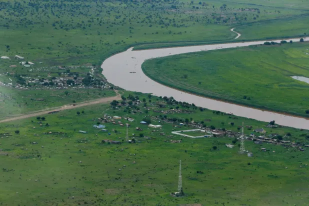 جزء من بلدة الناصر يظهر من نافذة طائرة شحن بعد إطلاق المساعدات الغذائية في المجال الجوي بجنوب السودان (رويترز)