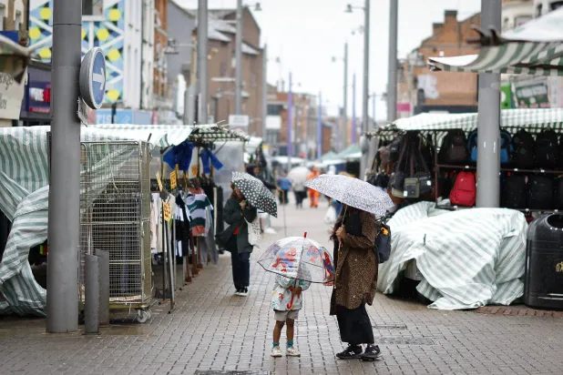 أناس يزورون سوق والثمستو خلال يوم ممطر في شرق لندن (إ.ب.أ)