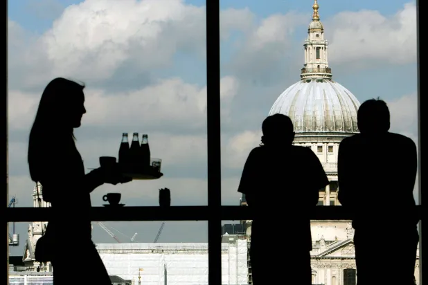 زوار يستمتعون بإطلالة كاتدرائية القديس بولس من طابق المطعم بمعرض تيت مودرن بلندن (رويترز)