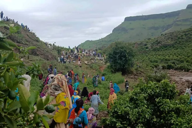 يتجمع الناس في موقع الانهيار الأرضي الذي دمر قرية ترسين بجبال مرة غرب دارفور (أ.ب)