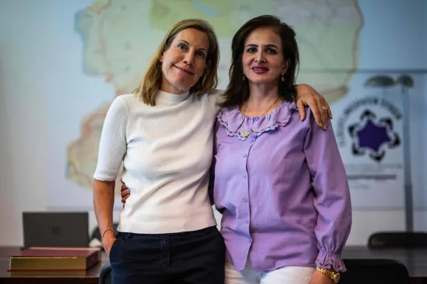 أسماء حويجة (يمين) التي وصلت إلى ألمانيا لاجئة من سوريا تلتقط صورة مع مديرة جمعية Fluechtlingspaten Syrien (رعاة اللاجئين السوريين) كاترين ألبريشت بمكتبها في برلين 10 يوليو 2025 (أ.ف.ب)