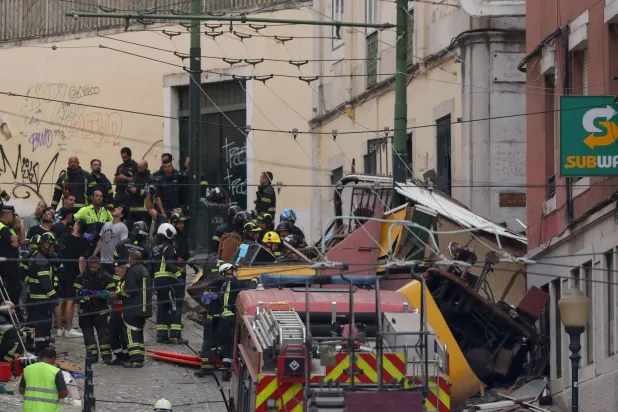 شرطة ورجال الإطفاء يعملون في موقع الحادث بلشبونة اليوم (أ.ف.ب)