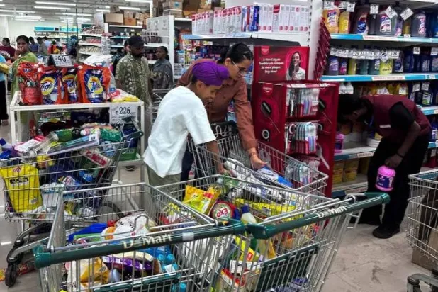 يتسوق الناس لشراء السلع الأساسية في سوبر ماركت بمدينة أمريتسار (رويترز)