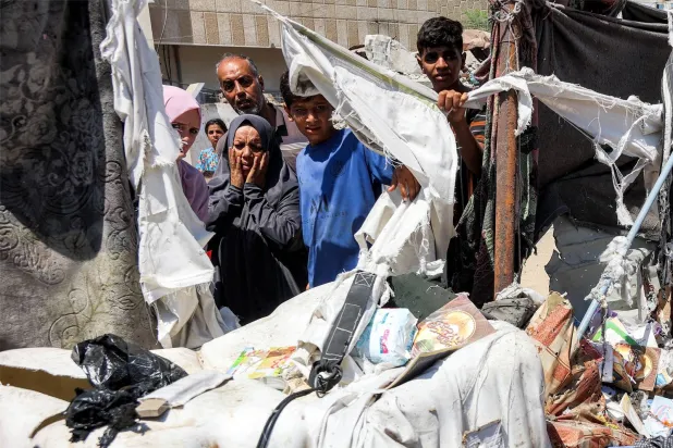 فلسطينيون يتفقدون أضرار غارة إسرائيلية على مدينة غزة (أ.ف.ب)