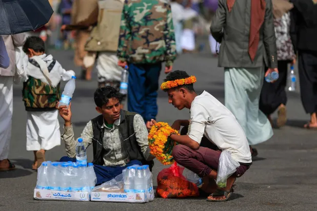 باعة متجولون يعرضون بضائعهم في صنعاء خلال حشد للحوثيين (أ.ف.ب)