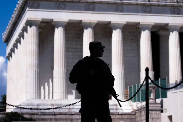 جندي مسلح من الحرس الوطني الأميركي يقف قرب نصب لينكولن التذكاري في واشنطن (أ.ف.ب) 