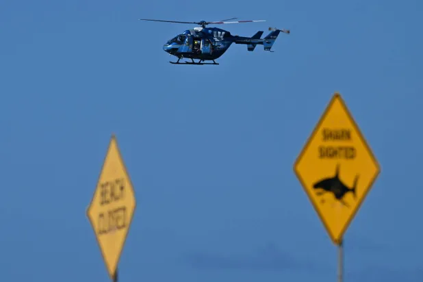 طائرة هليكوبتر تراقب مياه شاطئ لونغ ريف بعد هجوم سمكة القرش (أ.ف.ب)