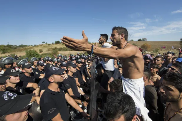 اللاجئون السوريون أمام الشرطة التركية 19 سبتمبر 2015 على الطريق السريع بين إسطنبول وأدرنة ينتظرون الحصول على إذن لعبور الحدود التركية اليونانية في أدرنة (أرشيفية-إ.ب.أ)