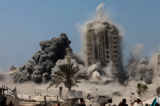 برج المشتهى في غزة خلال عملية تدميره يوم الجمعة (أ.ف.ب)