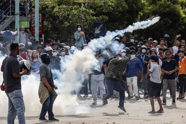 متظاهرون يشتبكون مع أفراد الشرطة خلال احتجاج أمام مبنى البرلمان في كاتماندو (أ.ف.ب)