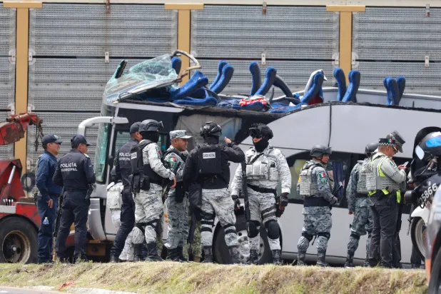 أفراد من الحرس الوطني وجنود من الجيش يصلون إلى موقع حادث اصطدام حافلة ركاب بقطار في أتلاكومولكو ولاية مكسيكو (أ.ف.ب)