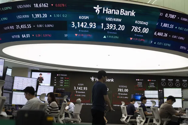 متداولون يعملون أمام الشاشات في بنك هانا بالعاصمة سيول (رويترز)