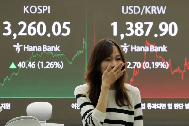 سيدة تمُر أمام شاشة تعرض حركة الأسهم في غرفة تداول «هانا بنك» في العاصمة الكورية الجنوبية سيول (إ.ب.أ)