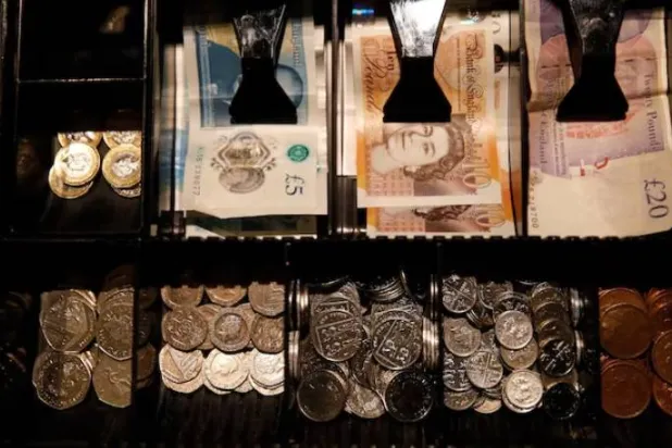 أوراق نقدية وعملات معدنية من فئة الجنيه الإسترليني في مقهى بمانشستر (رويترز)
