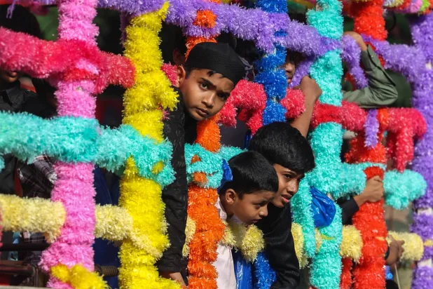 أطفال ينظرون من شاحنة مزينة في الهند (إ.ب.أ)