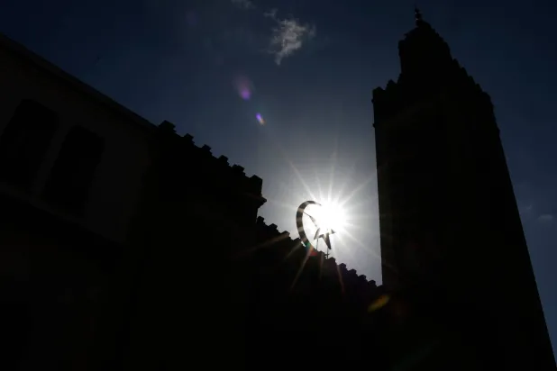 الشمس تظهر خلف النجمة والهلال على مدخل المسجد الكبير في باريس (أ.ف.ب)