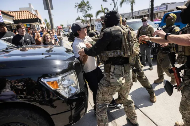 عناصر أمنية توقف شخصاً في لوس أنجليس (أ.ف.ب)