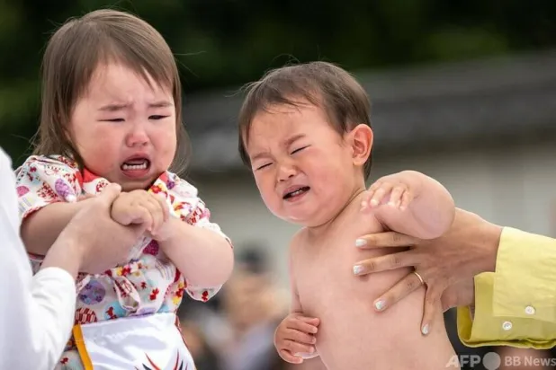 أطفال يحتضنهم آباؤهم ويبكون في طوكيو (أرشيفية - أ.ف.ب)