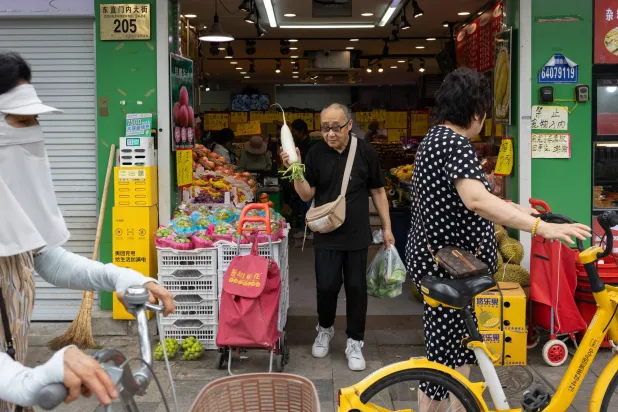 متسوقون خارج أحد المتاجر بالعاصمة الصينية بكين (إ.ب.أ)