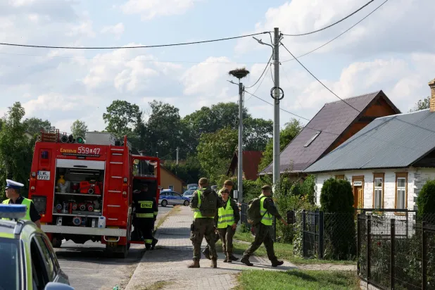 رجال الإطفاء وضباط الدفاع الإقليمي والشرطة يعملون بجوار موقع دمر فيه سقف منزل بعد سقوط مسيّرة في ويريكي... محافظة لوبلين في بولندا... 10 سبتمبر 2025 (رويترز)