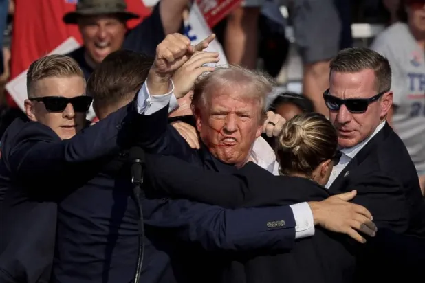 المرشح الجمهوري للرئاسة آنذاك دونالد ترمب يتلقى مساعدة من جهاز الخدمة السرية بعد إطلاق نار خلال تجمع انتخابي في بتلر بولاية بنسلفانيا عام 2024 (رويترز)