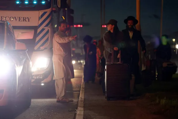 مسافرون يعودون سيراً على الأقدام إلى مبنى الركاب الذي أُعيد فتحه بعد أن استجابت خدمات الطوارئ لما وصفته بـ«حادث مواد خطرة محتمل» في مبنى الركاب «رقم 4» بمطار هيثرو في هونسلو بلندن - 8 سبتمبر 2025 (رويترز)