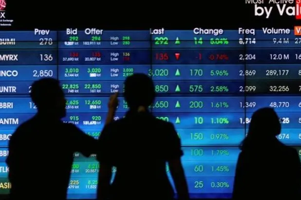 يقف الزوار بجانب لوحة الأسهم الإلكترونية في بورصة إندونيسيا بجاكرتا (رويترز)