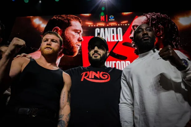 تركي آل الشيخ يتوسط الملاكمين كانيلو وكروفورد بعد نهاية المؤتمر الصحافي (الشرق الأوسط)