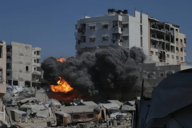 تصاعد النيران والدخان عقب غارة إسرائيلية على مبنى في مدينة غزة (أ.ب)