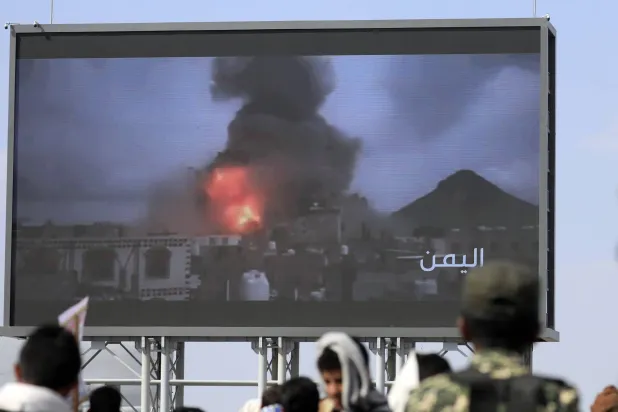 تجمع أنصار الحوثيين أمام لوحة إعلانية رقمية تُظهر انفجارات ناجمة عن الغارات الإسرائيلية الأخيرة على موقع في صنعاء خلال احتجاج ضد إسرائيل في العاصمة (إ.ب.أ)