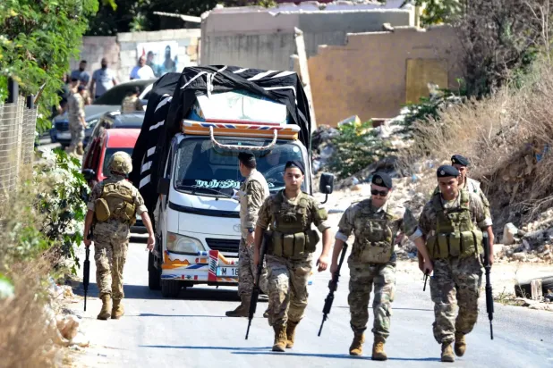 Lübnan'ın kuzeyindeki Beddavi Mülteci Kampında Fetih Hareketi’nin orduya teslim ettiği silahlarla yüklü bir kamyona eşlik eden Lübnan askerleri (AFP)