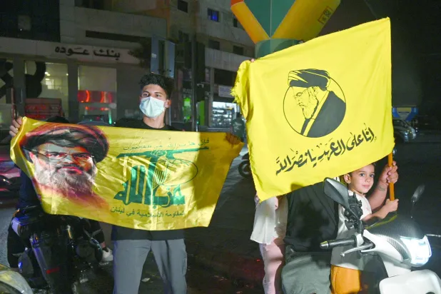 مناصرون لـ«حزب الله» يرفعون أعلامه وصورة أمينه العام الراحل حسن نصر الله في تحرك محدود بالضاحية الجنوبية لبيروت الأسبوع الماضي (إ.ب.أ)