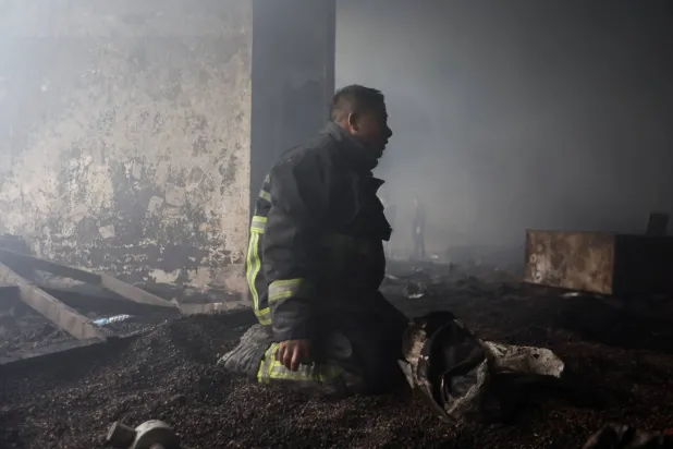 رجل إطفاء يعمل في إخماد حريق نشب في سوبر ماركت أثناء الاحتجاجات ضد الفساد في نيبال (رويترز)