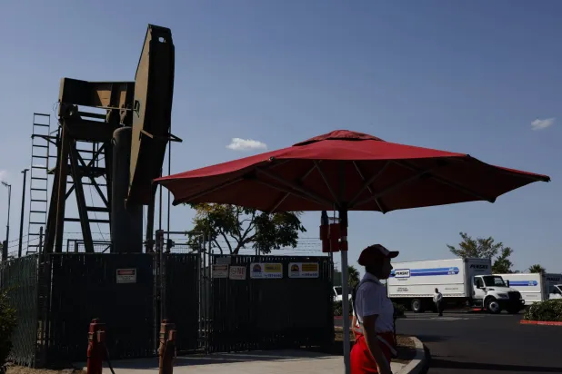 موظفة بمطعم تتلقى الطلبات خلال تشغيل منصة نفطية قريبة في سيغنال هيل بكاليفورنيا (إ.ب.أ)