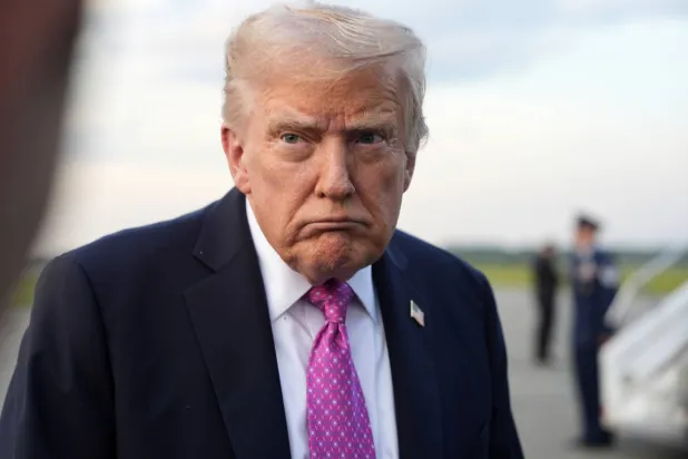 الرئيس الأميركي دونالد ترمب يتحدث إلى المراسلين قبل صعود طائرة الرئاسة في مطار موريس تاون (أ.ب)