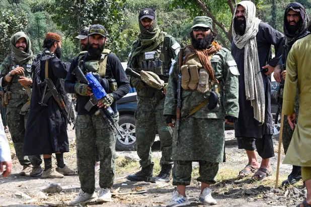 أفراد أمن من «طالبان» بالقرب من خيام مؤقتة نُصبت عقب زلزال في قرية مزار دارا بمقاطعة نورغال بولاية كونار الأحد... وزار نائب رئيس الوزراء الأفغاني شرق البلاد 12 سبتمبر ليصبح أول عضو في حكومة طالبان يقوم بهذه الزيارة بعد نحو أسبوعين من زلزال قوي أودى بحياة أكثر من 2200 شخص (أ.ف.ب)