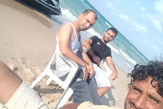 الفلسطيني محمد أبو دخة يلتقط «سيلفي» مع زملائه ضياء (27 عاماً) وباسم (23 عاماً) في لامبيدوسا (رويترز)