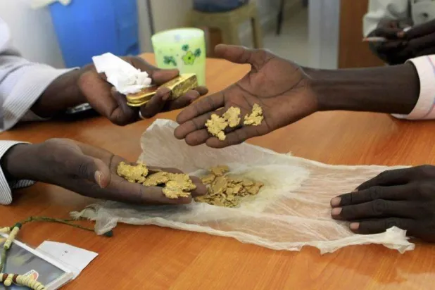 عمال في منجم ذهب أثناء عملية وزن خام الذهب في شمال دارفور (رويترز)