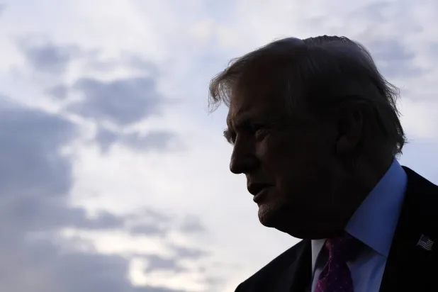 ترمب يتحدث مع الصحافيين قبل صعوده إلى طائرة الرئاسة في مطار موريس تاون (أ.ب)