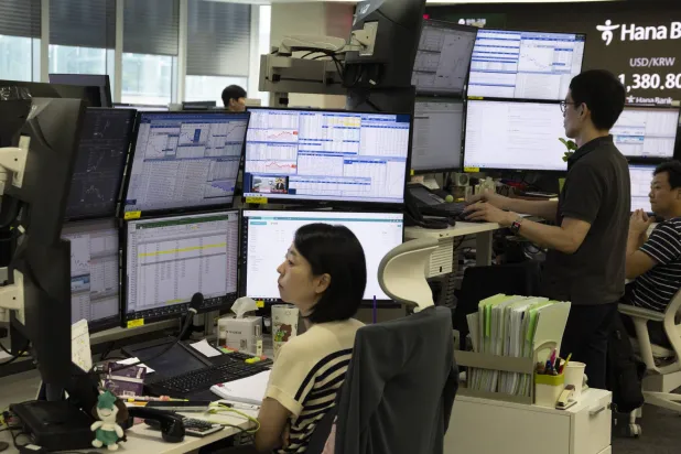 متداولون أمام شاشات المراقبة في بنك هانا بسيول في كوريا الجنوبية (إ.ب.أ)