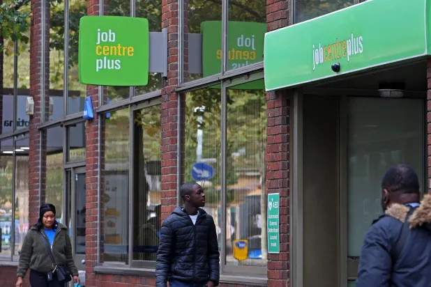 أشخاص يسيرون بجانب مركز الوظائف «جوب سنتر بلس» في لندن (رويترز)