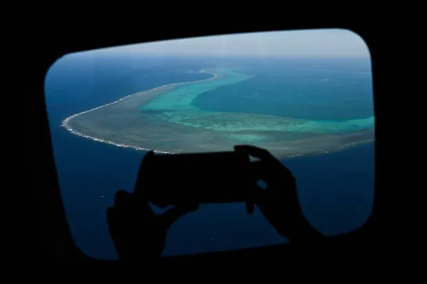 A reporter takes a video over the Scarborough Shoal in the disputed South China Sea on February 16, 2024. (AFP)