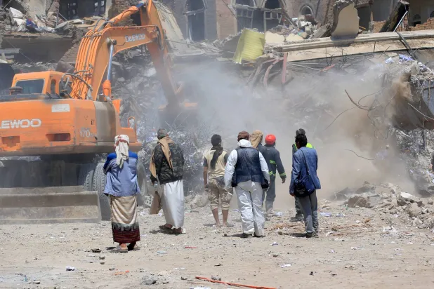 آلية تزيل الركام من موقع خاضع للحوثيين استهدفته إسرائيل (أ.ف.ب)