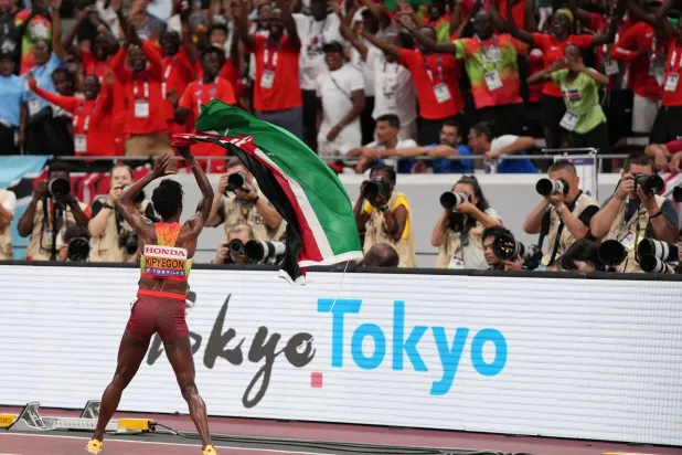 العدّاءة الكينية تحتفل مع الجماهير بالميدالية الذهبية (رويترز)