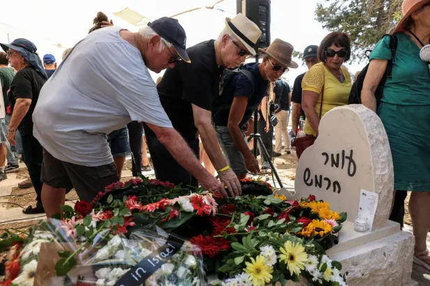 Ailesi ve arkadaşları, 7 Ekim 2023'teki saldırıda hayatını kaybeden bir İsraillinin cenazesinin, İsrail'in güneyindeki Kibbutz Kfar Aza'daki evinin yakınına nakledilmesinin ve yeniden gömülmesinin ardından anma törenine katıldı. (Reuters)