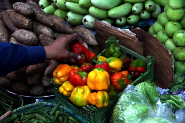 بائع يعرض الخضار على جانب الطريق بكراتشي في باكستان (إ.ب.أ)